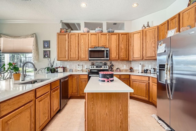 kitchen featuring a kitchen island, sink, backsplash, stainless steel appliances, and a textured ceiling