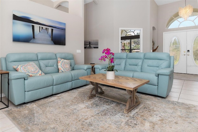 tiled living room featuring a high ceiling and an inviting chandelier