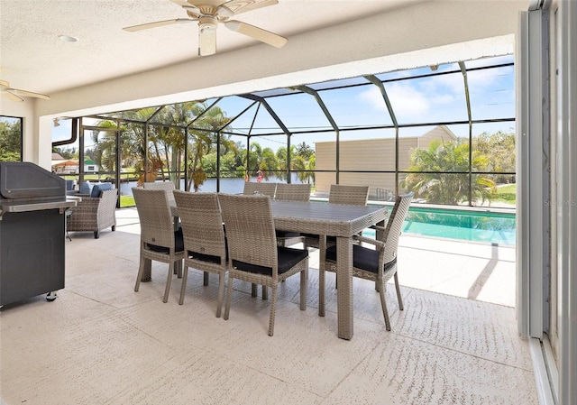 view of patio with a water view, ceiling fan, an outdoor hangout area, and glass enclosure