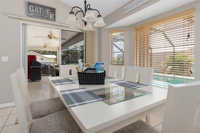 tiled dining area featuring ceiling fan with notable chandelier and a healthy amount of sunlight