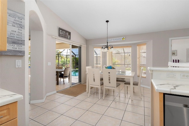 dining space with lofted ceiling, light tile patterned floors, and a healthy amount of sunlight