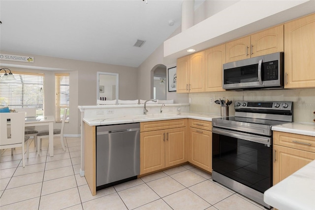 kitchen featuring light tile patterned flooring, appliances with stainless steel finishes, sink, and light brown cabinets