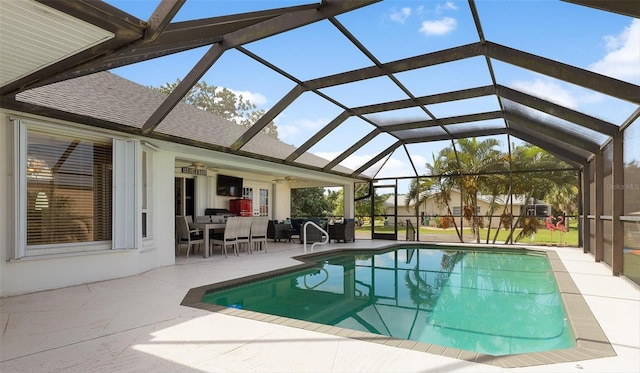 view of swimming pool featuring ceiling fan, a lanai, and a patio area