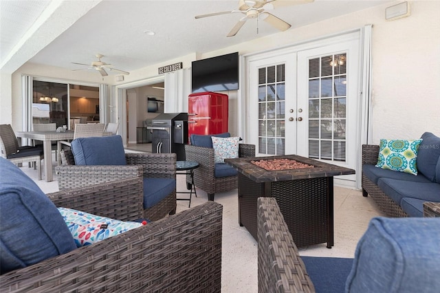 view of patio / terrace featuring an outdoor living space with a fire pit, french doors, and ceiling fan