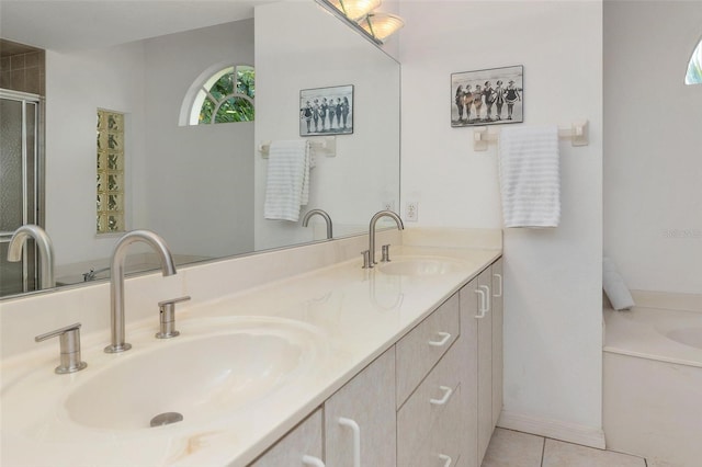 bathroom featuring tile patterned flooring, vanity, and a washtub