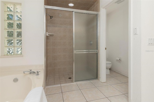 bathroom with tile patterned floors, toilet, and separate shower and tub