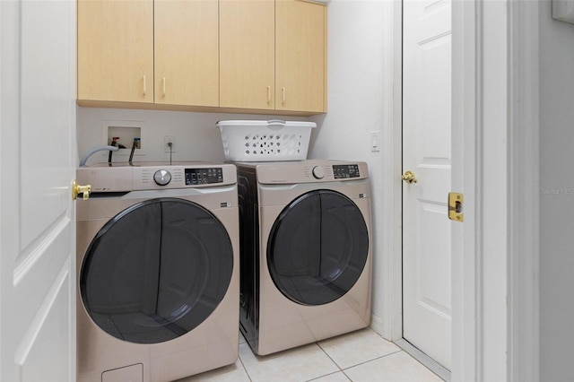 laundry area with independent washer and dryer, cabinets, and light tile patterned flooring