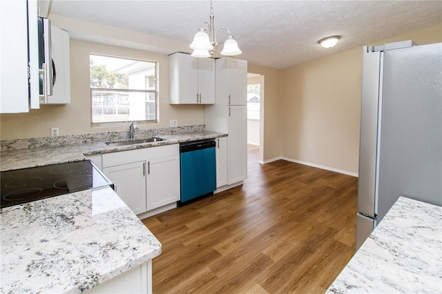 kitchen with light wood-style flooring, freestanding refrigerator, white cabinetry, a sink, and dishwasher