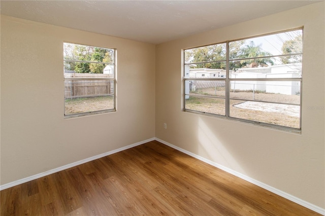 empty room featuring baseboards and wood finished floors