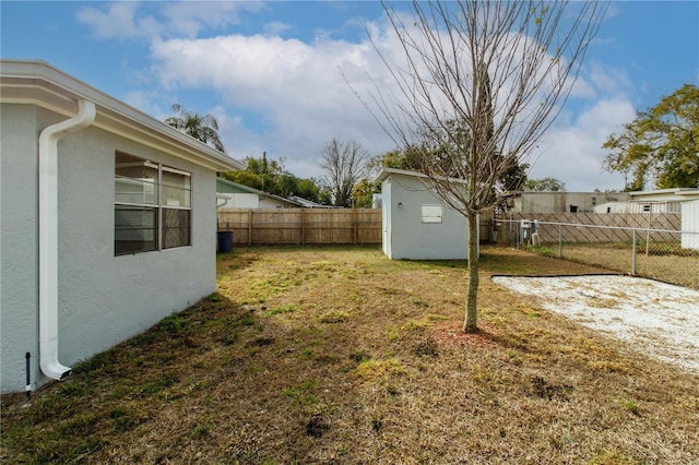 view of yard with a fenced backyard, an outdoor structure, and a storage shed