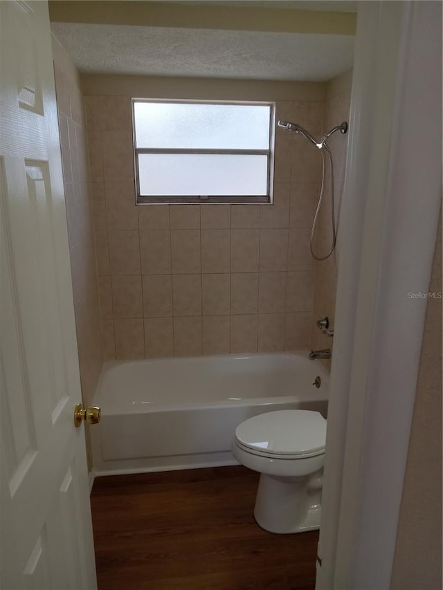 full bath featuring shower / tub combination, plenty of natural light, wood finished floors, and toilet