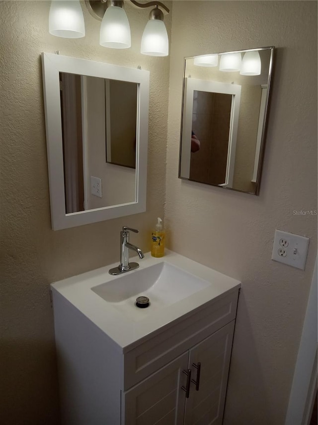 bathroom featuring a textured wall and vanity