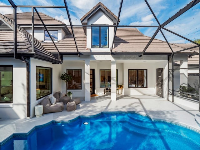 back of house with an outdoor living space, a patio, and a lanai