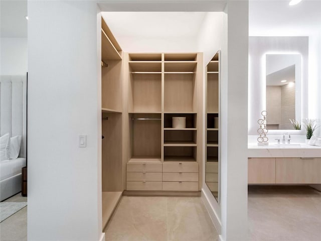 walk in closet featuring sink and light tile patterned floors