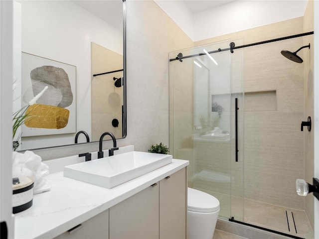 bathroom with vanity, a shower with door, and toilet