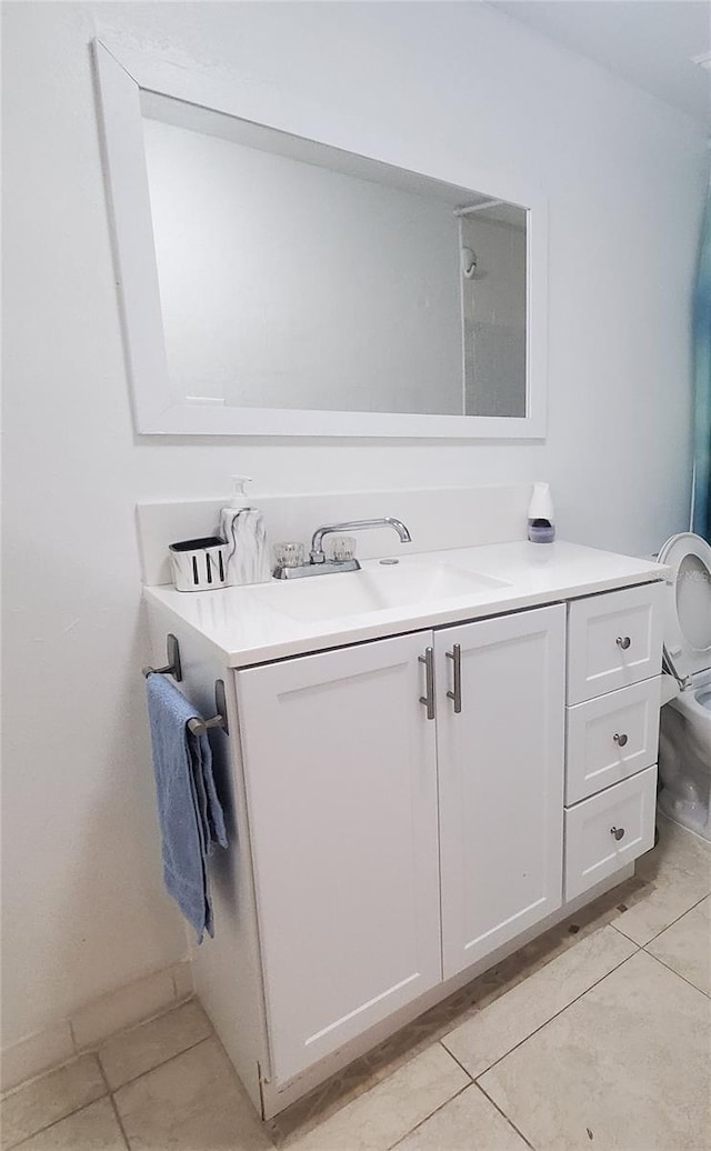 bathroom featuring tile patterned flooring, vanity, and toilet