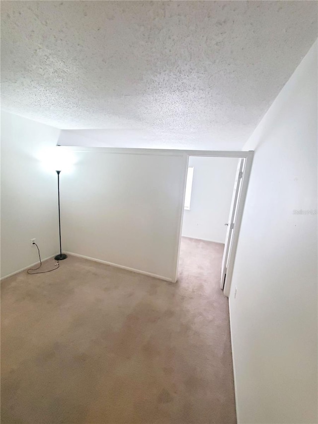 carpeted empty room featuring a textured ceiling