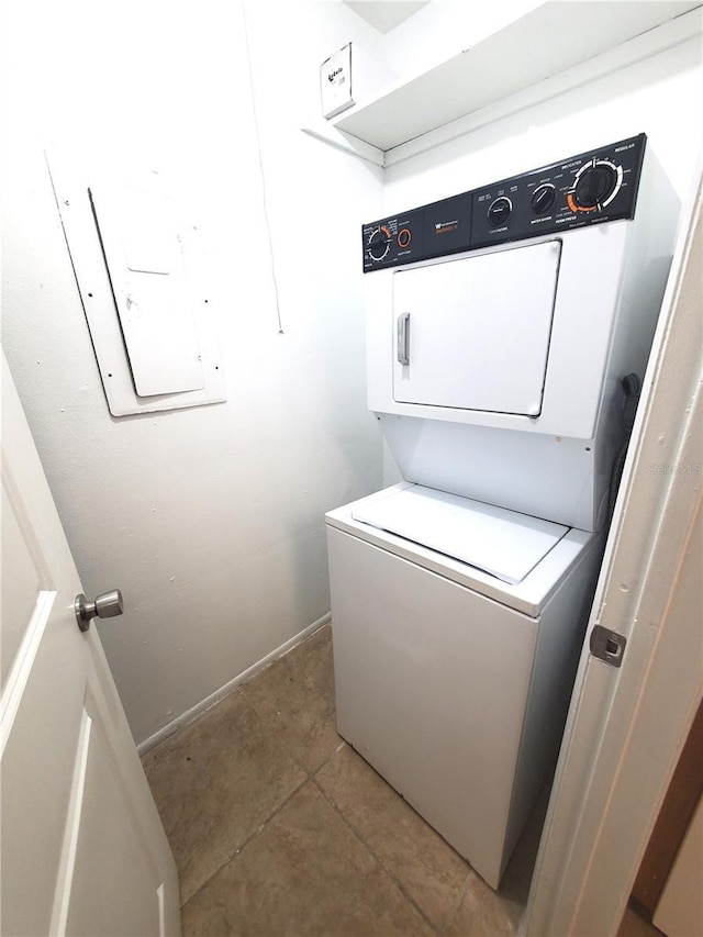 laundry area with tile patterned floors and stacked washer and clothes dryer