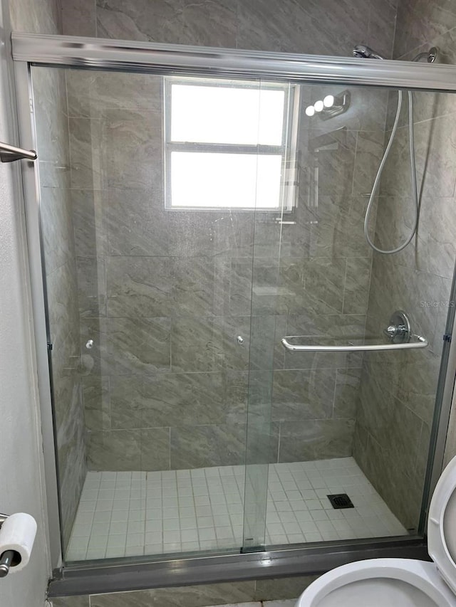 bathroom with toilet and an enclosed shower