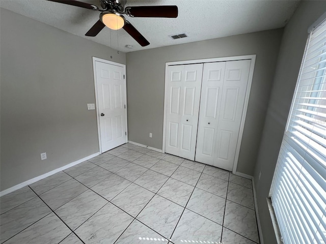 unfurnished bedroom featuring a textured ceiling, a closet, and ceiling fan