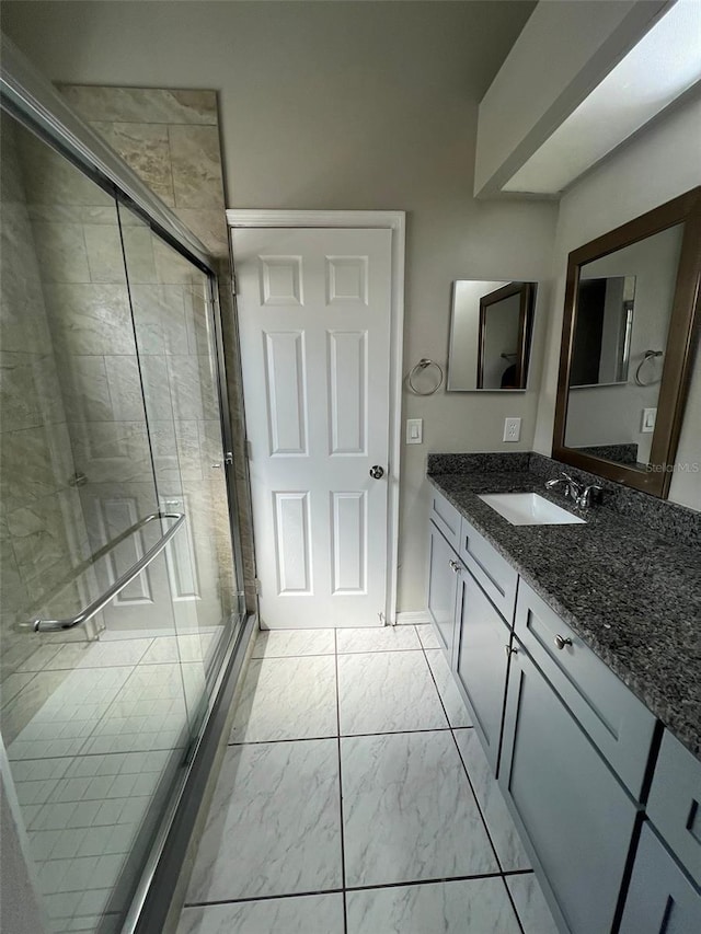 bathroom with vanity and a shower with door