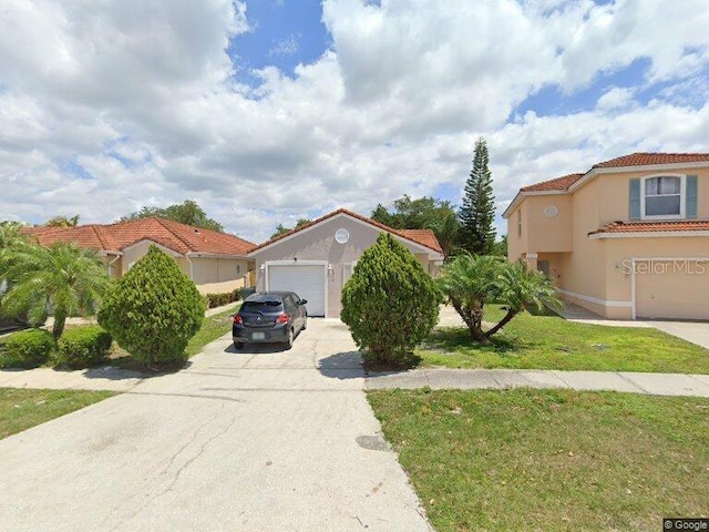 mediterranean / spanish house featuring a garage and a front lawn