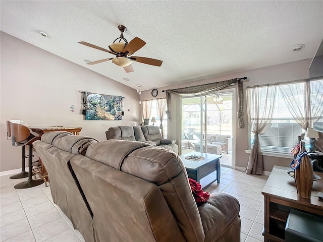 tiled living room featuring lofted ceiling, ceiling fan, and a textured ceiling