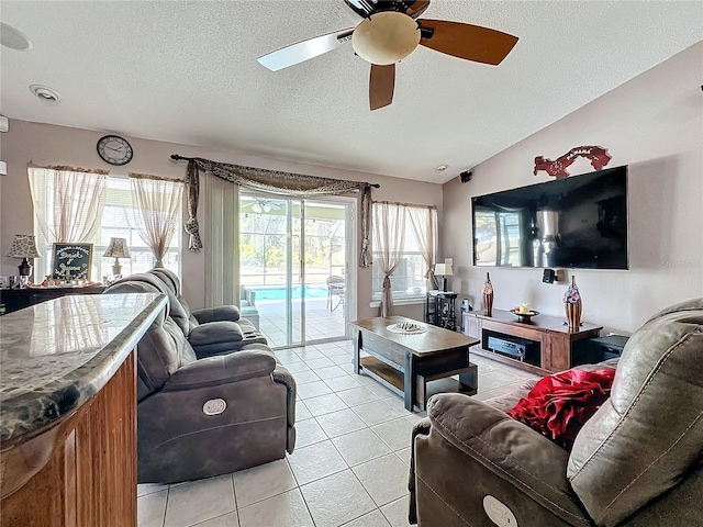 living room with vaulted ceiling, a wealth of natural light, and light tile patterned flooring