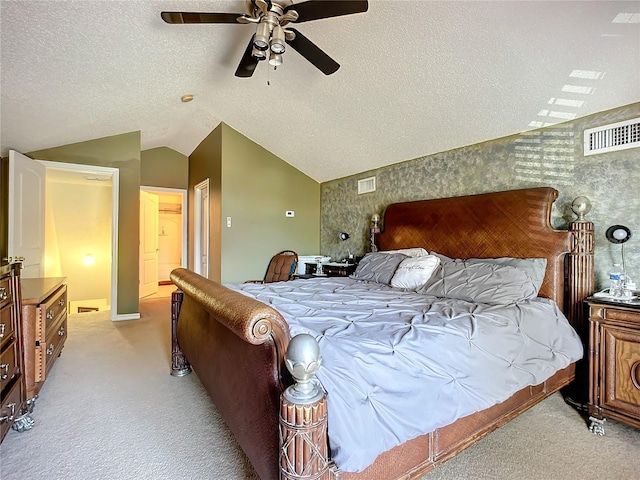 bedroom featuring ceiling fan, vaulted ceiling, light colored carpet, and a textured ceiling