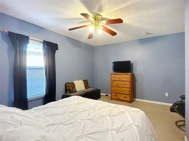 carpeted bedroom with ceiling fan and a textured ceiling