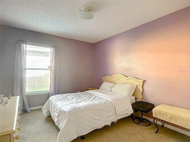 bedroom featuring light carpet and a textured ceiling