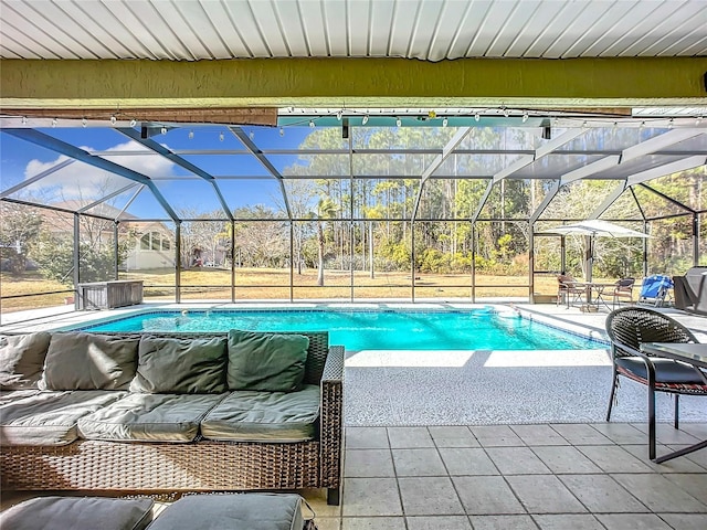 view of swimming pool with outdoor lounge area, a patio, and glass enclosure