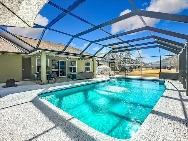 view of pool featuring an outdoor living space, a lanai, a patio, and ceiling fan