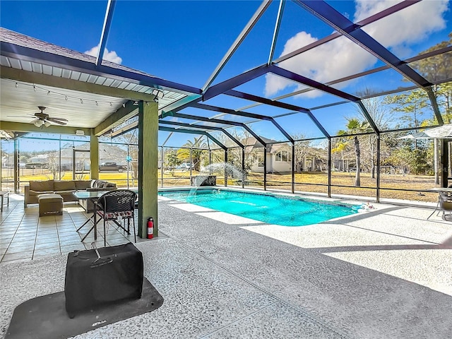 view of pool featuring a patio, outdoor lounge area, ceiling fan, and glass enclosure