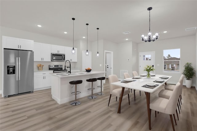 dining area with sink and light hardwood / wood-style floors