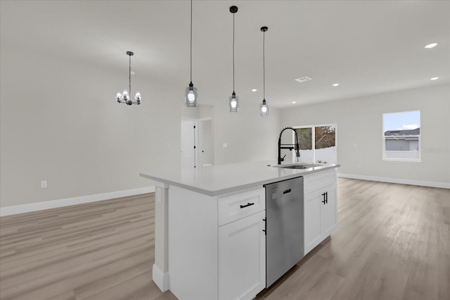 kitchen featuring pendant lighting, white cabinetry, dishwasher, sink, and an island with sink