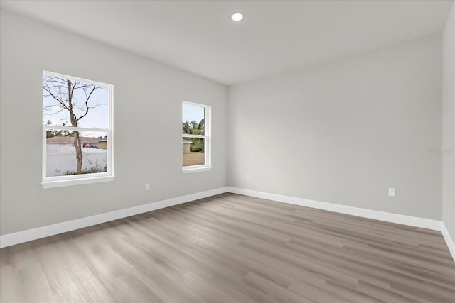 unfurnished room with recessed lighting, wood finished floors, and baseboards