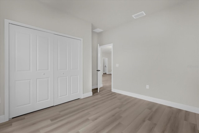 unfurnished bedroom with a closet and light wood-type flooring