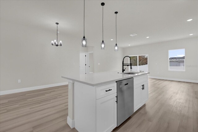 kitchen with dishwasher, baseboards, light wood-style floors, and a sink