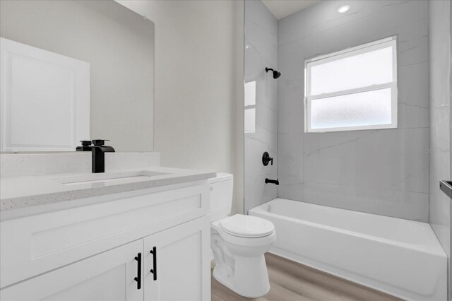 full bathroom with shower / bathtub combination, wood finished floors, vanity, and toilet