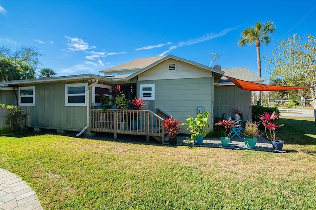 back of house with a deck and a lawn