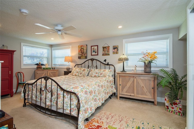 carpeted bedroom with multiple windows, a textured ceiling, and ceiling fan