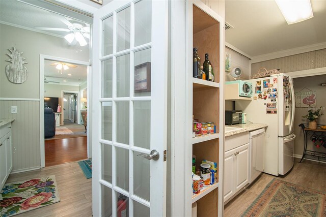 kitchen featuring white appliances, light hardwood / wood-style flooring, ceiling fan, ornamental molding, and white cabinets