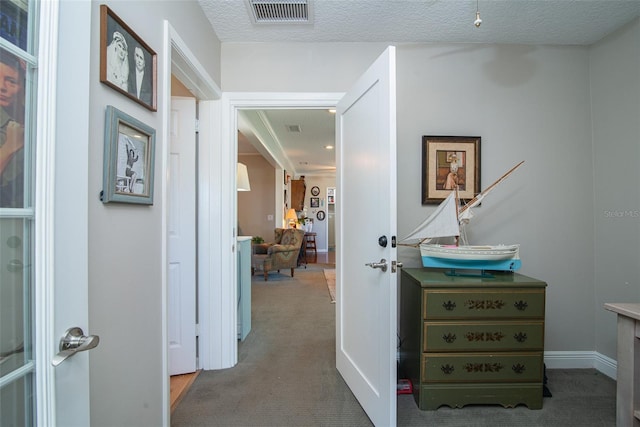 hall with a textured ceiling and carpet