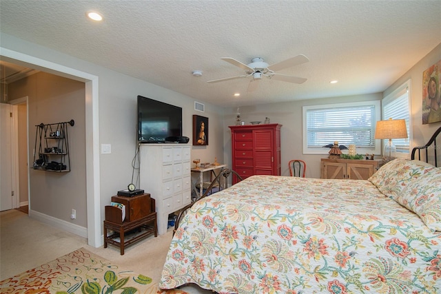 bedroom with light carpet, a textured ceiling, and ceiling fan