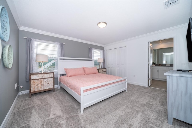 carpeted bedroom featuring crown molding, ensuite bath, and a closet