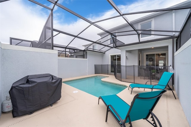 view of swimming pool with area for grilling, glass enclosure, and a patio area