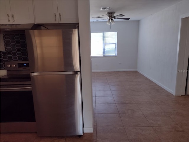 kitchen with stainless steel appliances, white cabinetry, light tile patterned floors, and ceiling fan