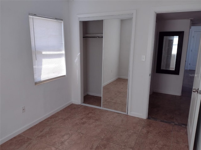 unfurnished bedroom featuring multiple windows and a closet