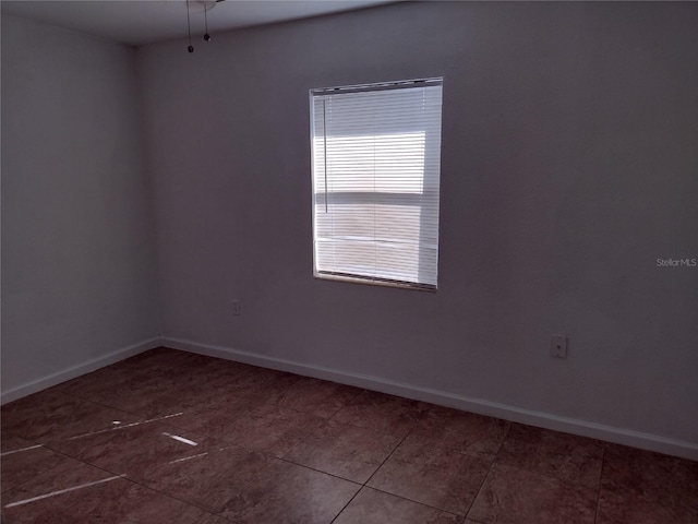 empty room featuring dark tile patterned floors